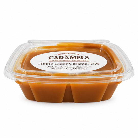 A clear plastic clamshell container of Karamow's Caramels Apple Cider Caramel Dip, showing the rich amber-brown caramel dip inside, on a clean white background.