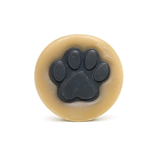 Round beige object with a black paw print design on a white background