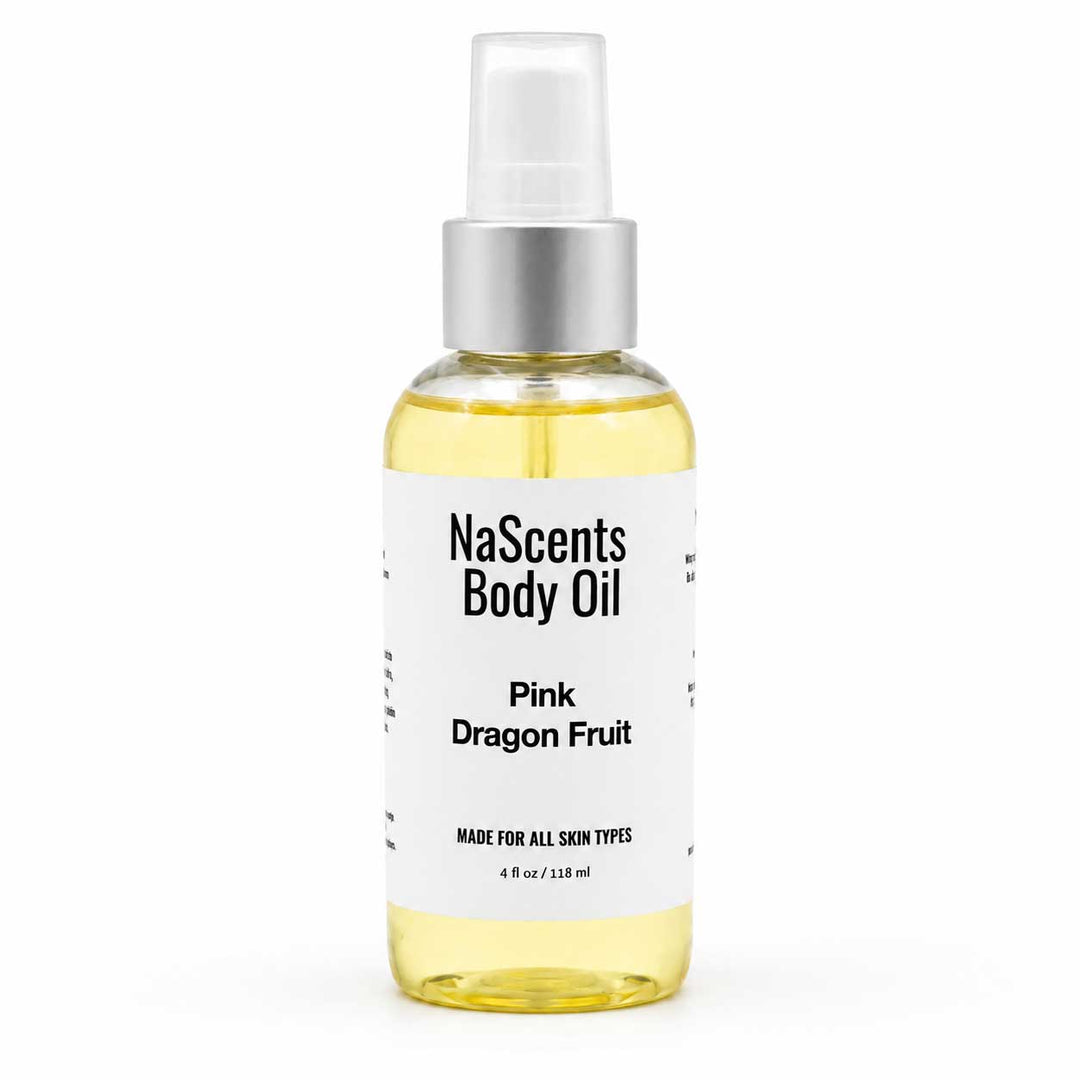 A bottle of NaScents Body Oil in the Pink Dragon Fruit scent, featuring a clear glass bottle filled with pale yellow oil, a white label with black text, and a silver spray nozzle on a white background.