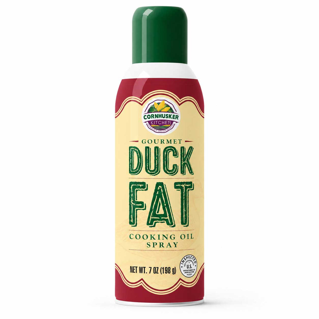 A 7 oz aerosol can of Cornhusker Creamery Gourmet Duck Fat Cooking Oil Spray, featuring a cream-colored label with green lettering and a dark green cap, set against a plain white background.