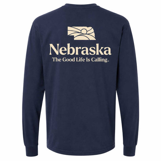 A navy blue long-sleeve t-shirt shown from the back, featuring a cream-colored graphic of the state of Nebraska with the text 'Nebraska' and 'The Good Life Is Calling.' printed below it.