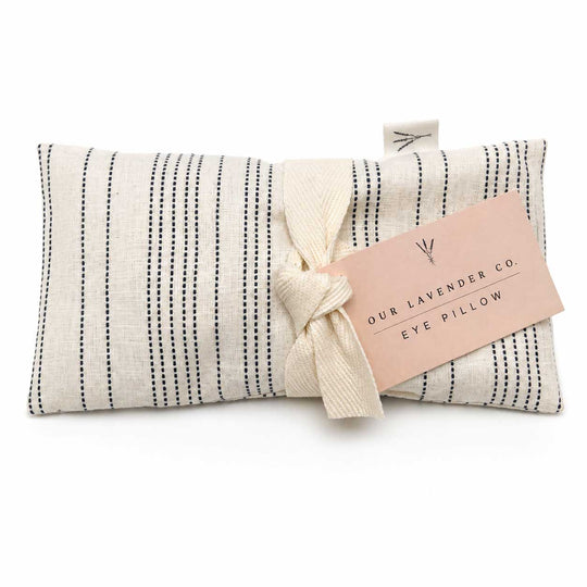 Eye pillow with black stripes and a pink tag labeled 'Our Lavender Co.' on a white background