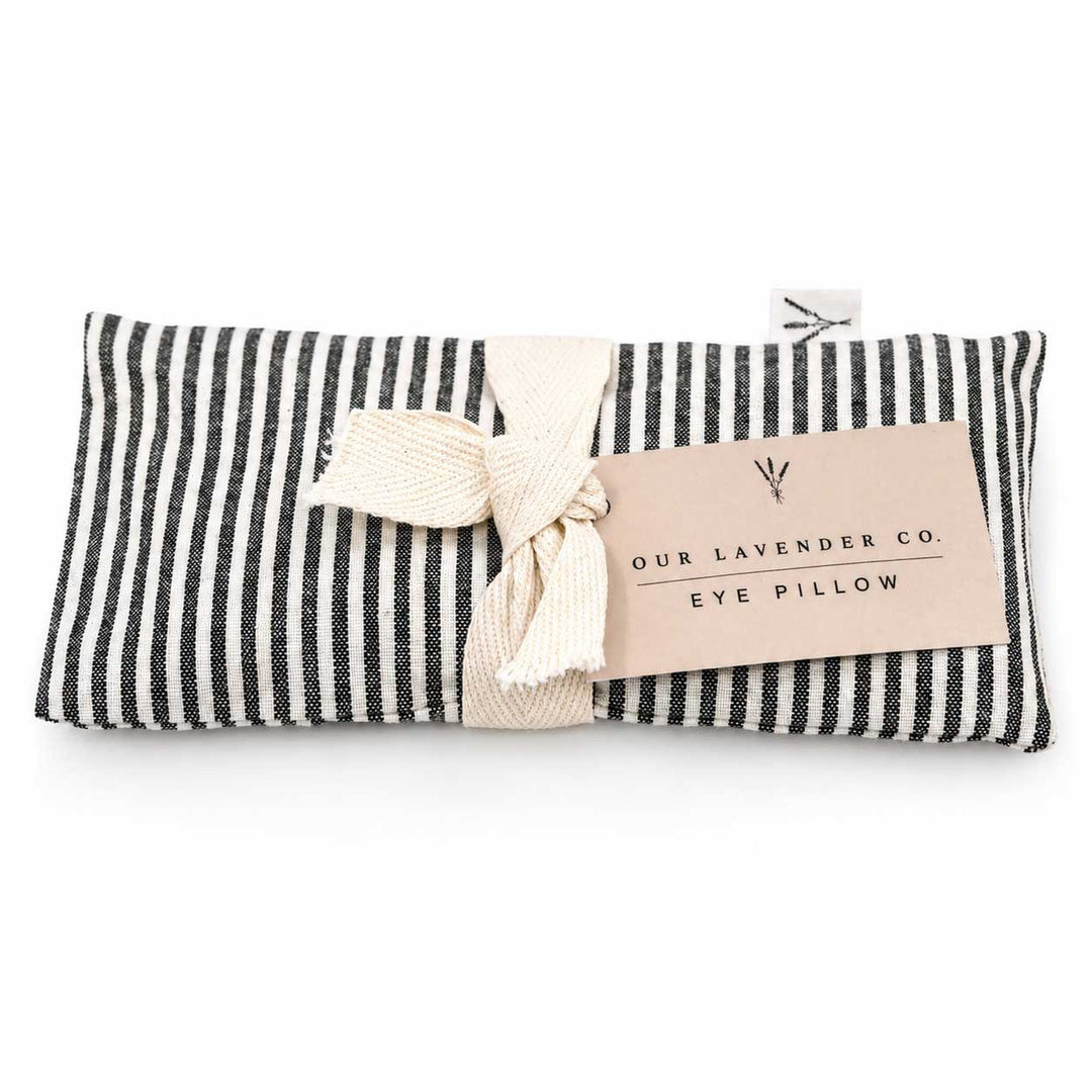 Black and white striped eye pillow with a bow and 'Our Lavender Co.' label on a white background