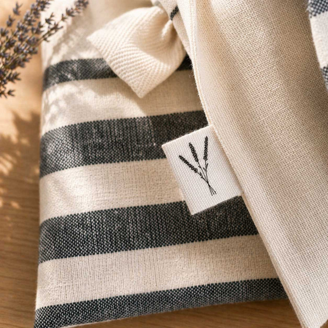 Close-up of a striped fabric with a brand tag featuring a plant design.
