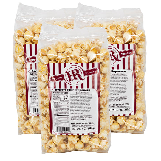 Three packages of sweet fire popanero popcorn with red and white labels on a white background.