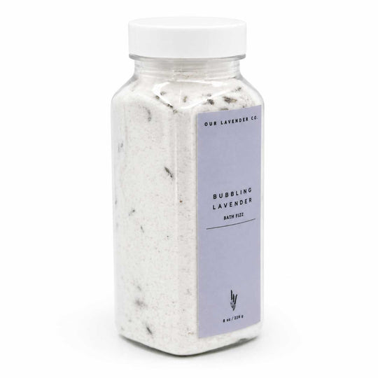 Bottle of 'Bubbling Lavender' bath fizz with a white lid on a white background