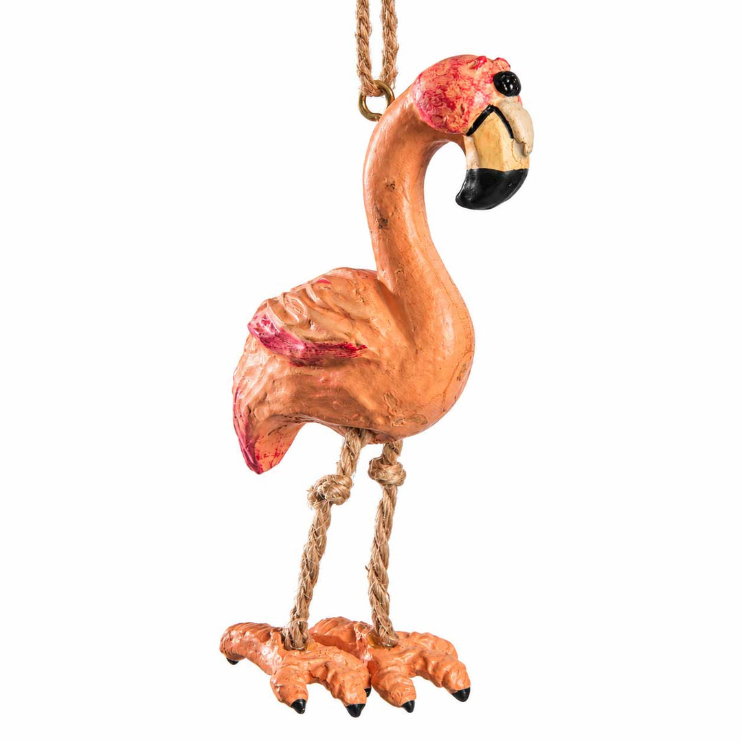 A hand-painted decorative flamingo ornament with a natural rope leg and hanging loop, shown against a plain white background.