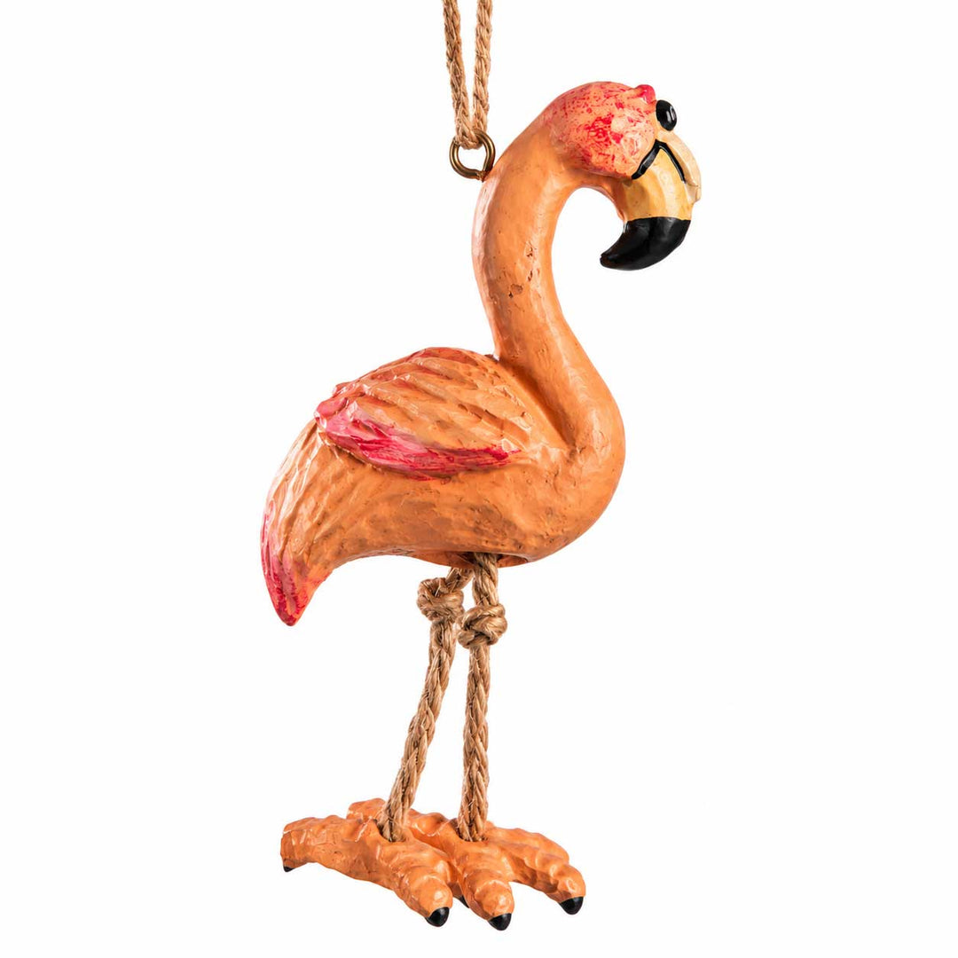 A decorative flamingo ornament hanging by a rope loop, shown against a plain white background. The ornament is primarily orange with pink accents on the wings and tail, a black beak tip, and a small red patch on the head.