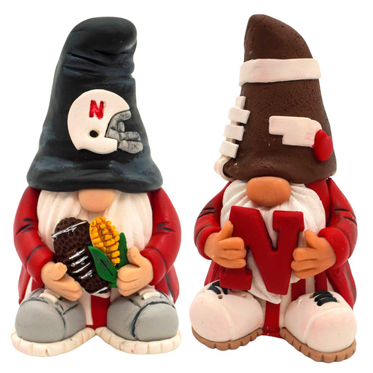 Two gnomes with husker football-themed accessories on a white background