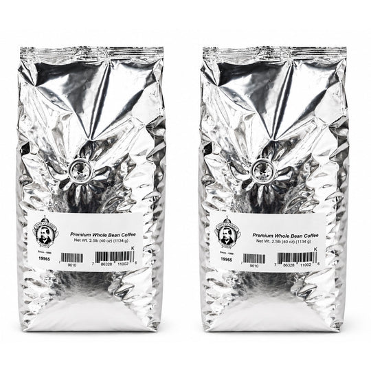 Two packages of premium whole bean coffee with labels on a white background