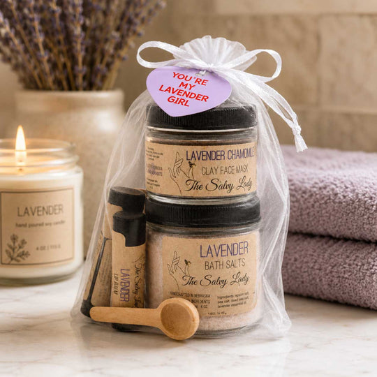 Set of lavender-themed skincare products with a candle and towel in the background