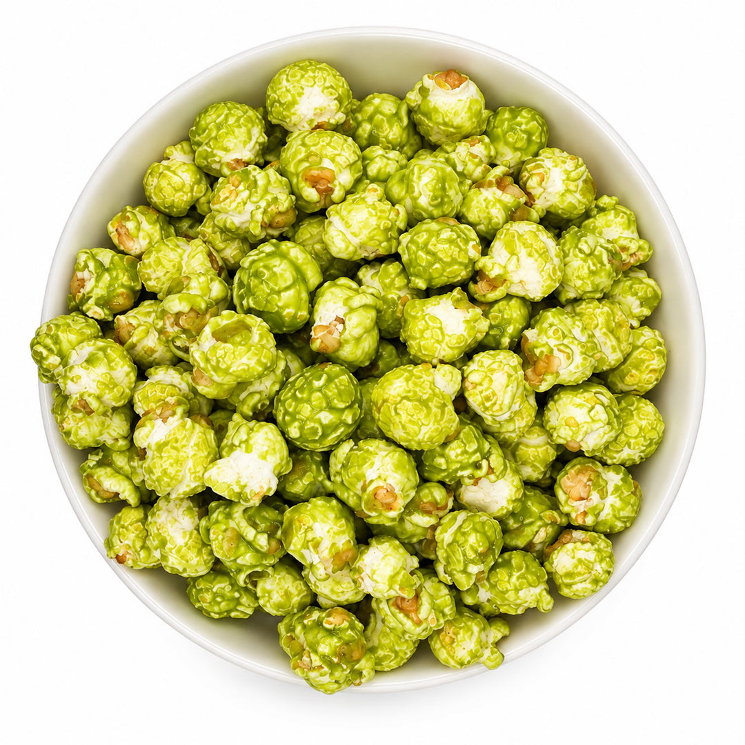 Green popcorn coated in white sauce, served in a white bowl on a white background.
