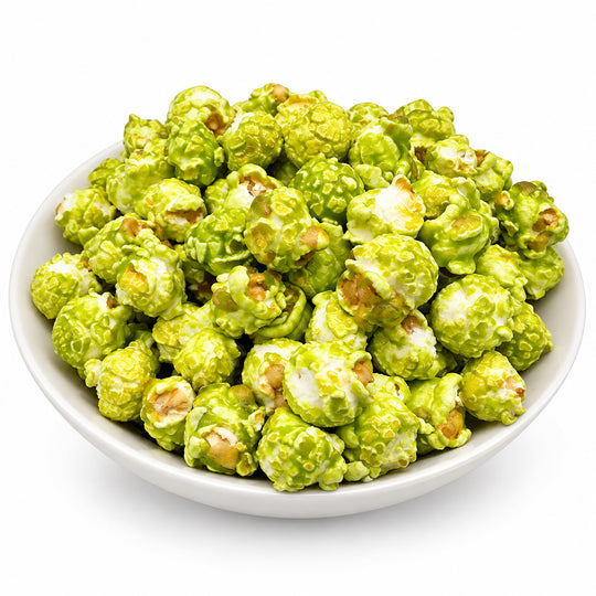 Green caramel popcorn piled in a white bowl on a clean white background.