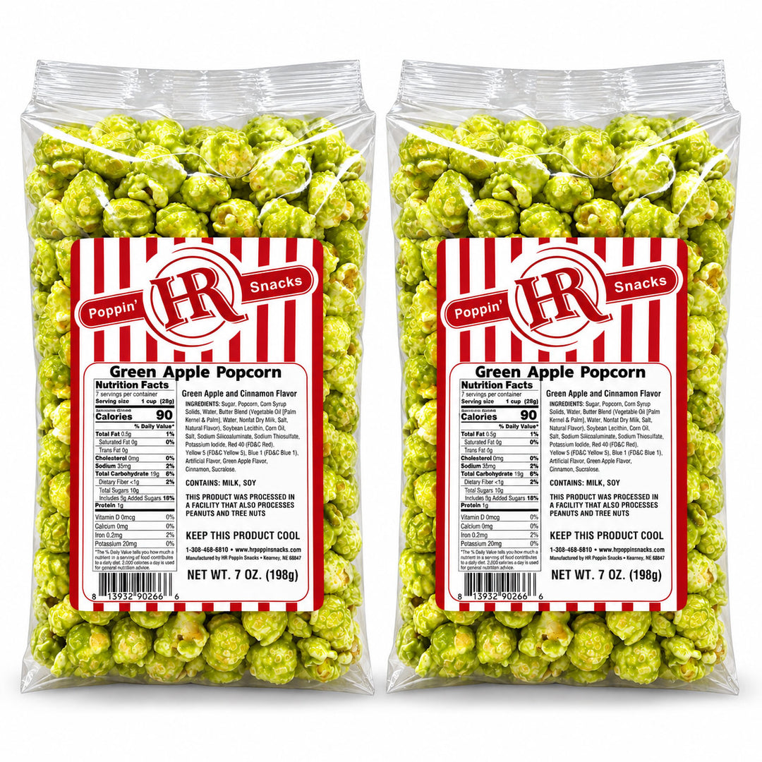Two clear plastic bags of Poppin' HR Snacks Green Apple Popcorn, filled with bright green popcorn and featuring a red and white striped label with product details.