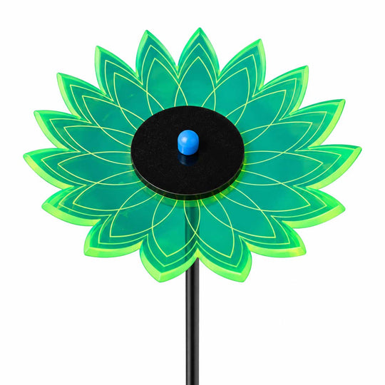 A flower-shaped solar garden stake with translucent green and blue petals, a black circular center, and a small blue solar panel on top, set against a solid white background.