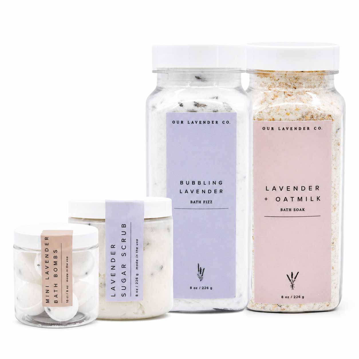 Set of lavender-themed bath products including a jar, bath fizz, and soap on a white background.
