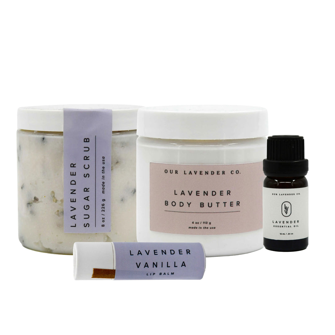 Set of lavender skincare products including scrub, body butter, lip balm, and essential oil on a white background.