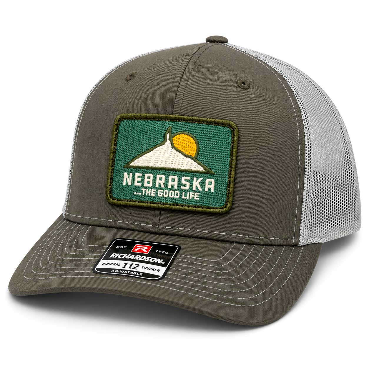 An olive green and gray trucker hat with a Nebraska patch on the front, featuring a curved brim and mesh back.