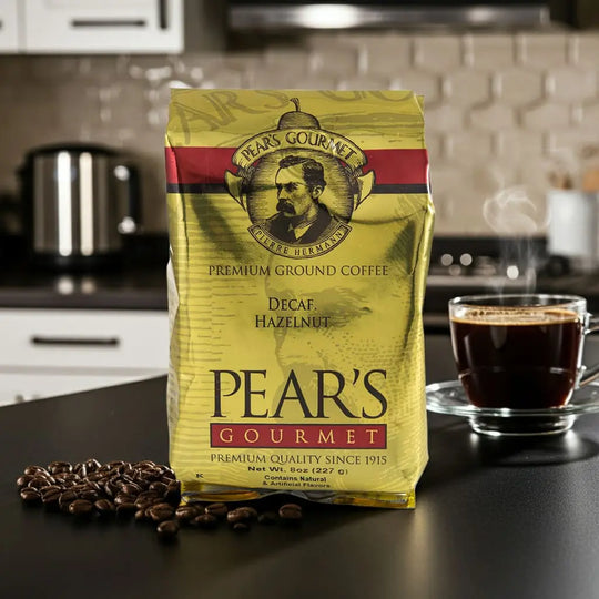 Pear's Gourmet coffee package with a cup of coffee and coffee beans on a kitchen counter.