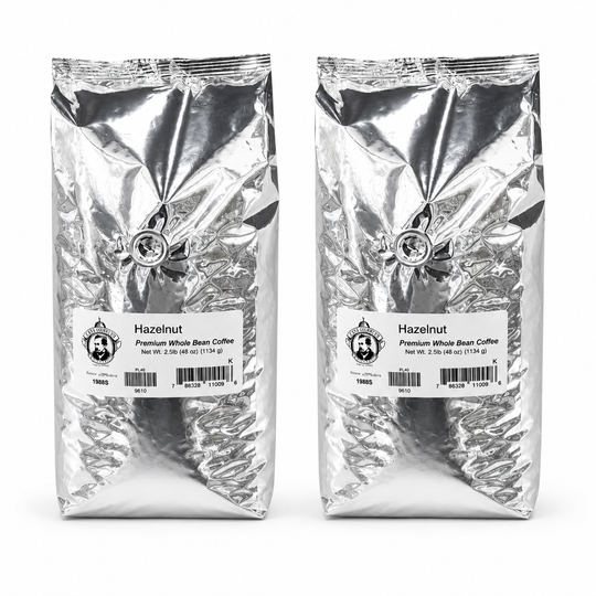 Two packages of hazelnut coffee beans with labels on a white background
