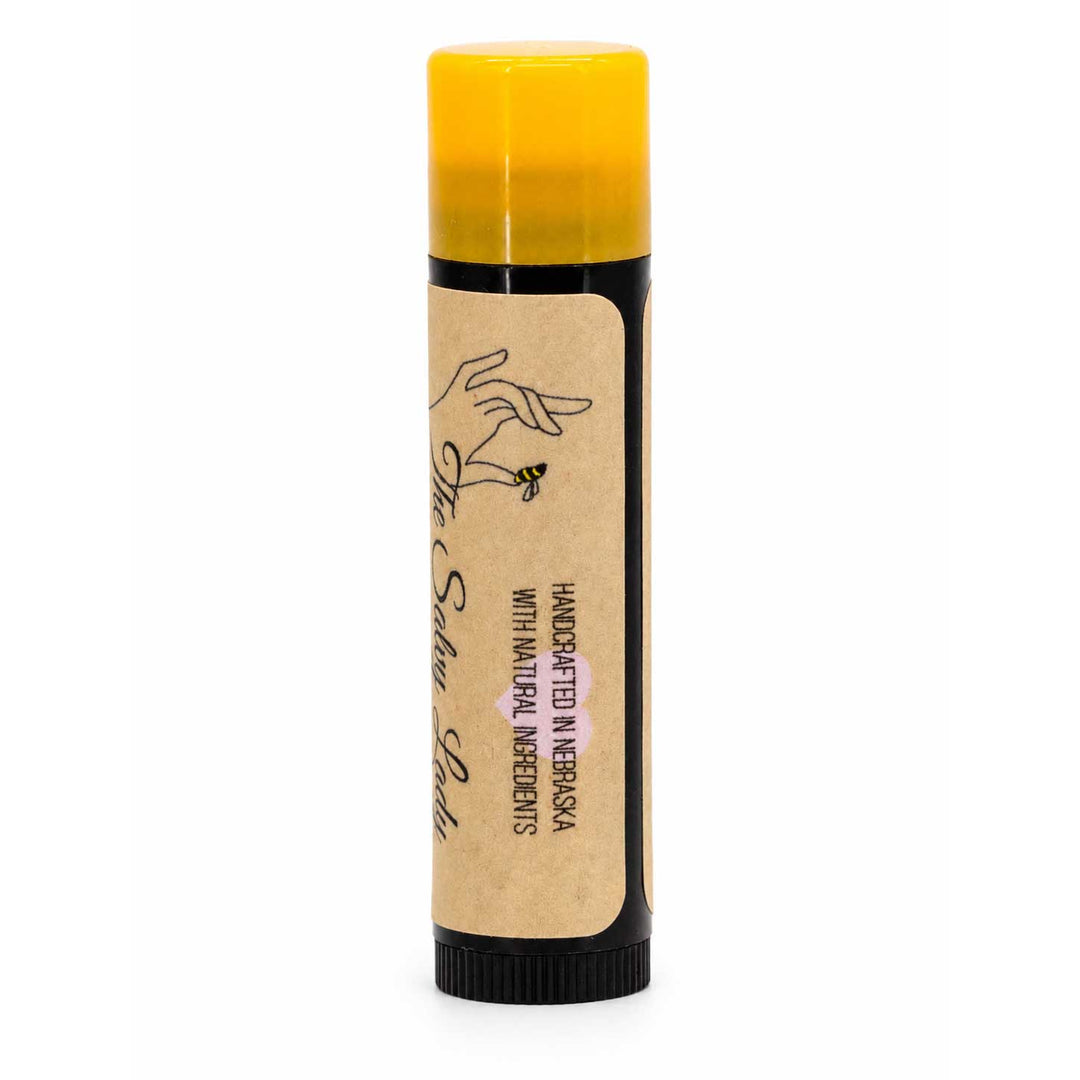 Lip balm with a yellow cap and brown label on a white background
