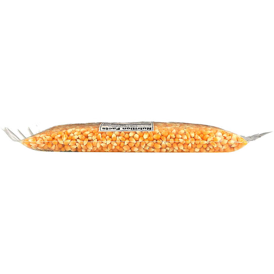 A clear plastic bag filled with yellow-orange corn kernels, sealed with silver metal ends and a white label in the center, shown on a plain white background.