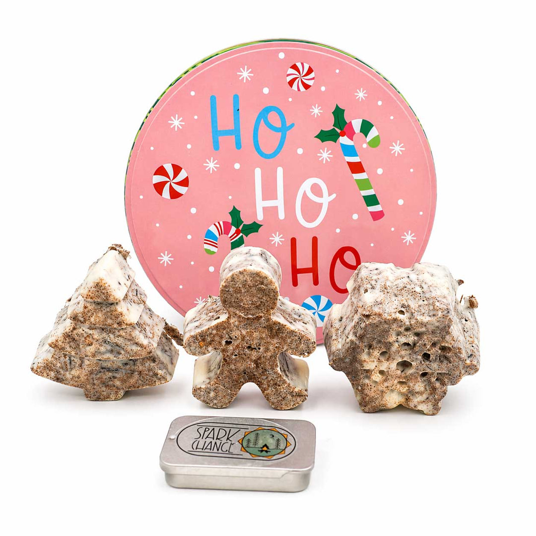 Decorative fire starters shaped like Christmas trees and a gingerbread man with a 'Ho Ho Ho' sign in the background.