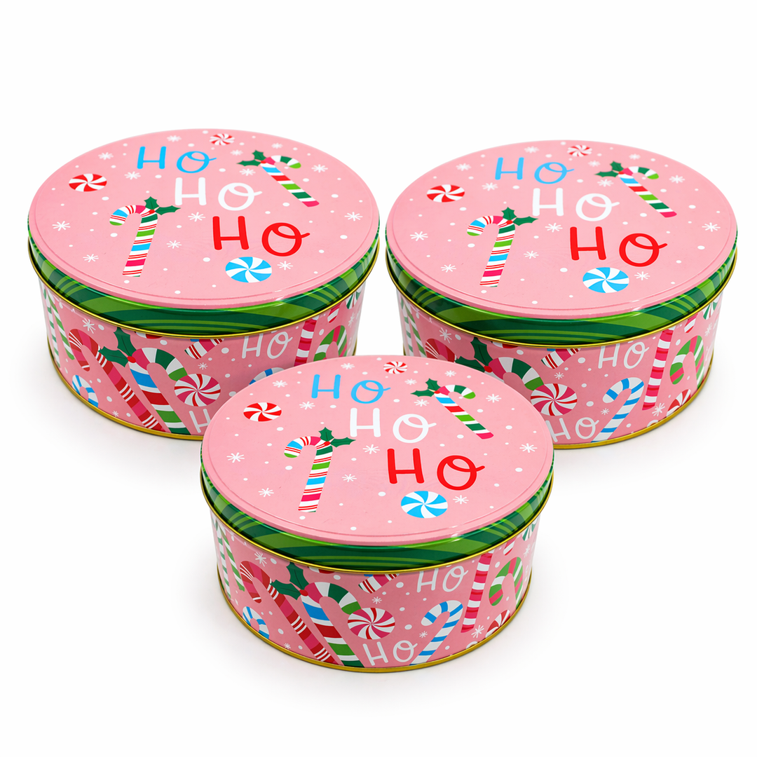 Three pink Christmas tins with candy cane designs and 'HO HO HO' text on a white background.