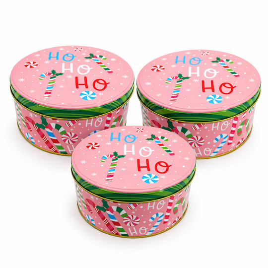 Three pink Christmas tins with candy cane designs and 'HO HO HO' text on a white background.
