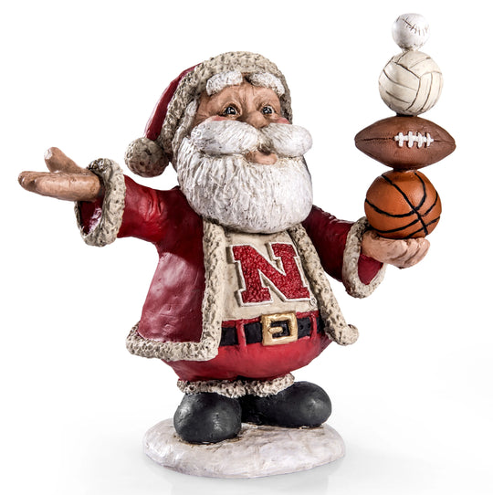 Santa Claus figurine holding sports balls with a visible 'N' on his robe against a white background