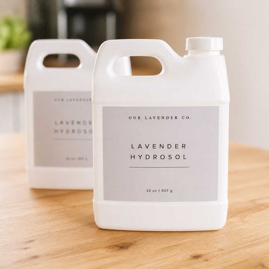 Two bottles of lavender hydrosol from 'Our Lavender Co.' on a wooden surface.
