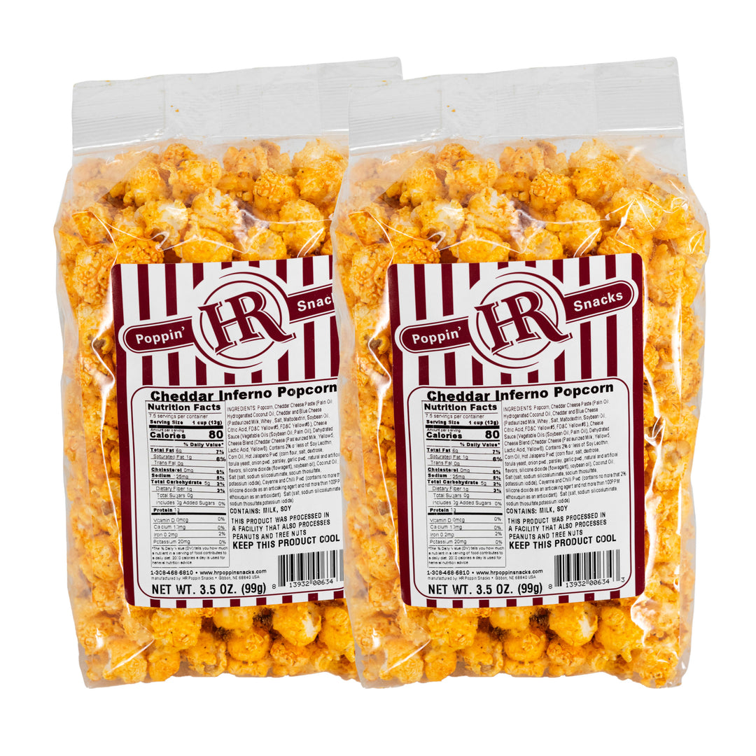 Two packages of Cheddar Inferno popcorn with visible labels on a white background