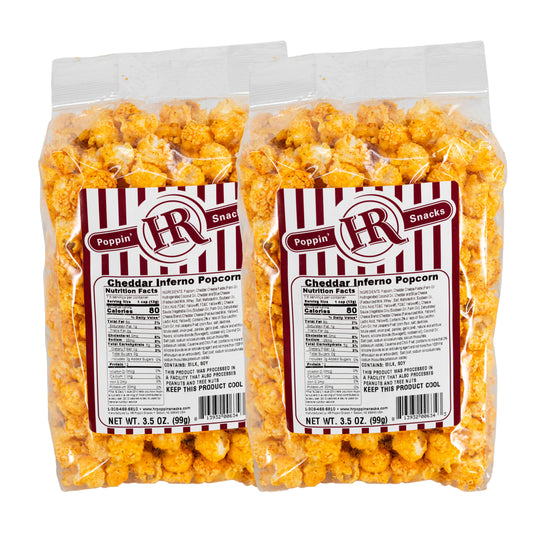 Two packages of Cheddar Inferno popcorn with visible labels on a white background
