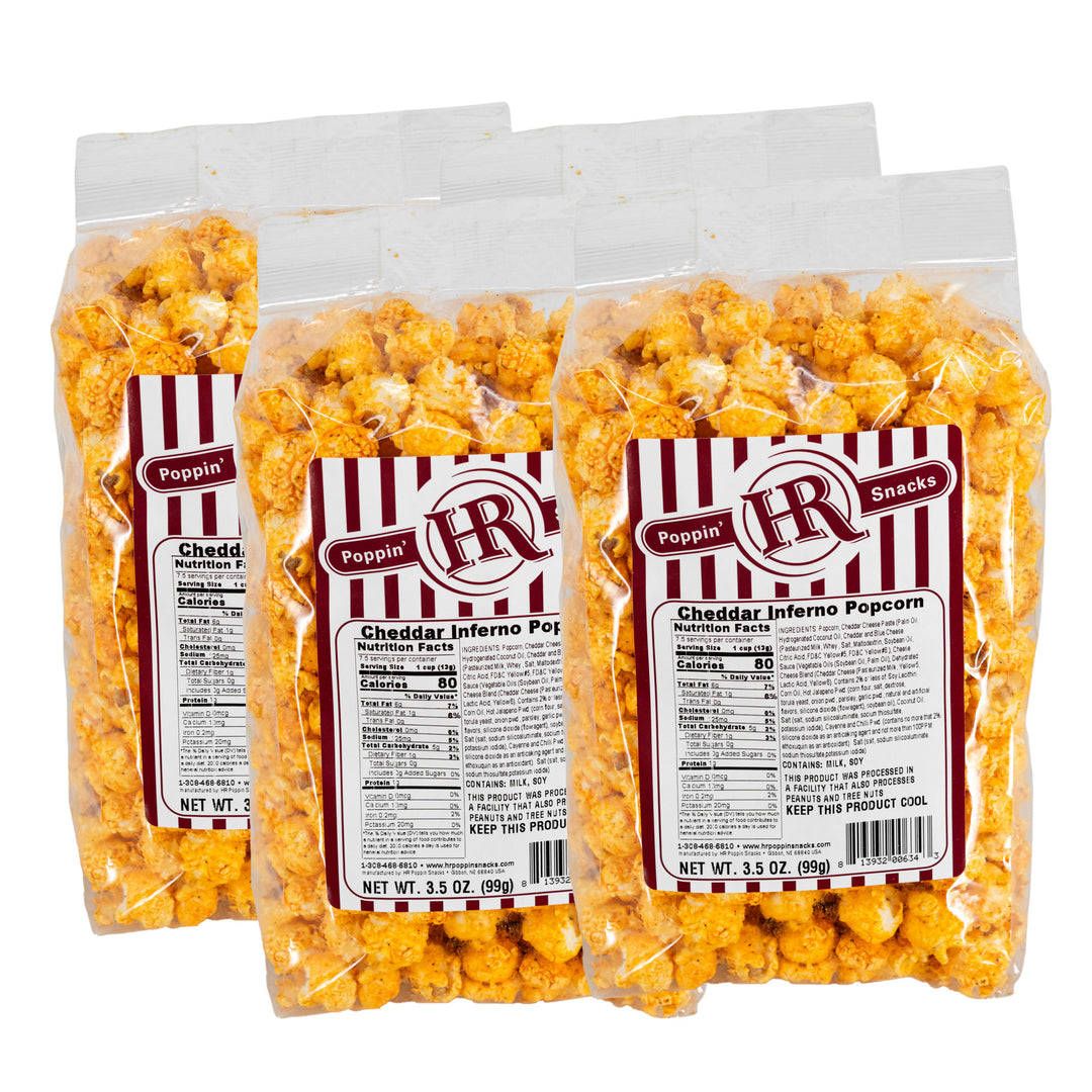Four packages of HR Poppin' Snacks Cheddar Inferno Popcorn with labels on a white background