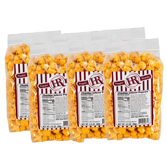 Six bags of cheddar inferno popcorn with red and white labels on a white background
