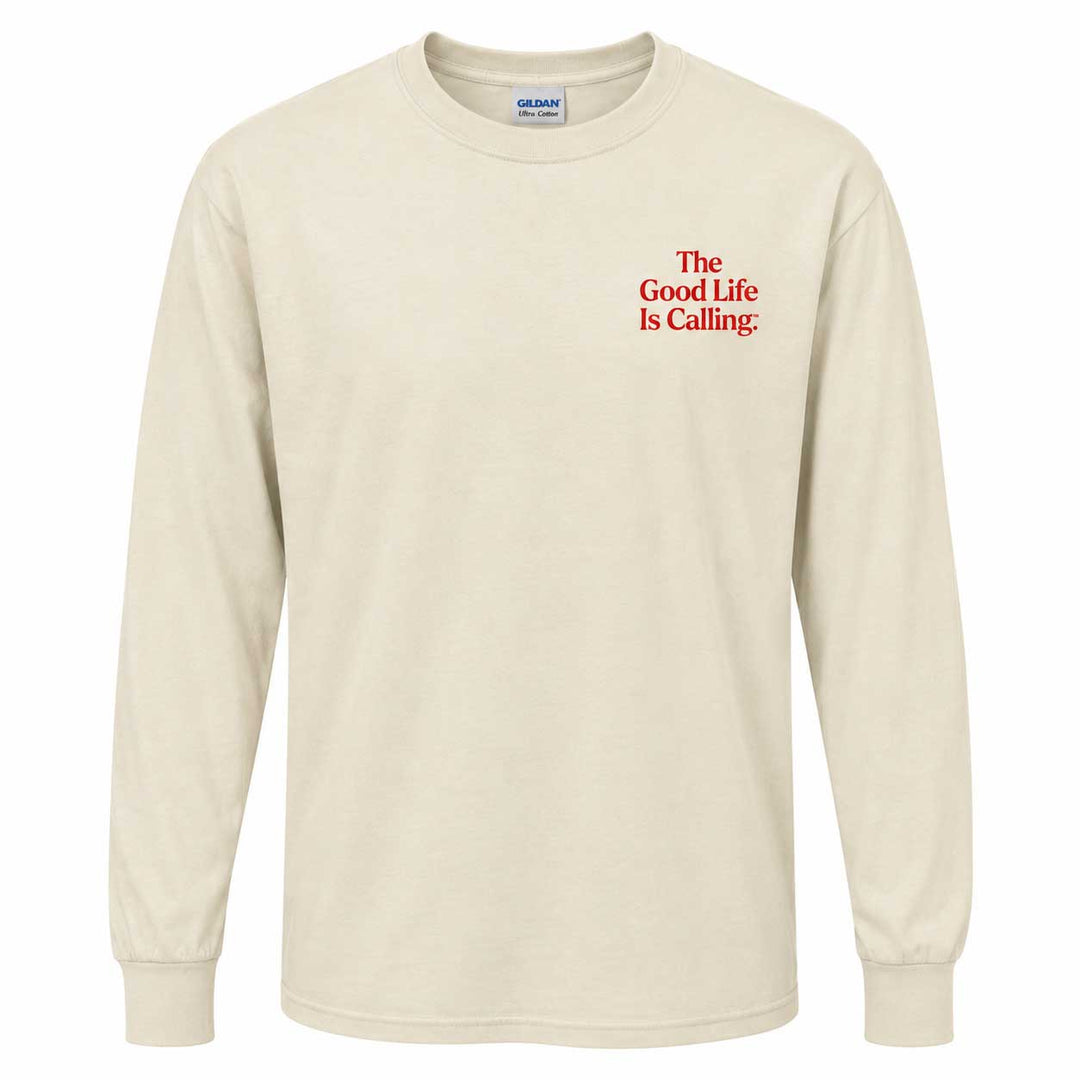 A cream-colored long-sleeve t-shirt with red text on the left chest reading 'The Good Life Is Calling.' The shirt is shown on a plain white background, with a Gildan brand tag visible inside the collar.