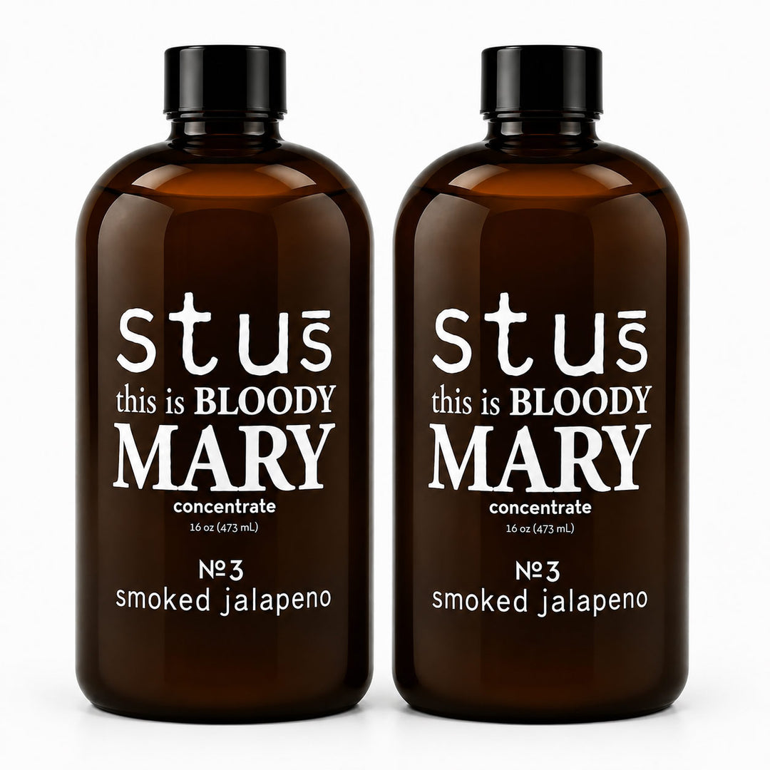 Two amber glass bottles with black caps, labeled 'stus this is BLOODY MARY concentrate' and 'No 3 smoked jalapeno', shown on a white background.