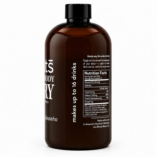 An amber glass bottle with a black cap, showing the back label with nutrition facts and text including 'makes up to 16 drinks' and 'calapeno'.