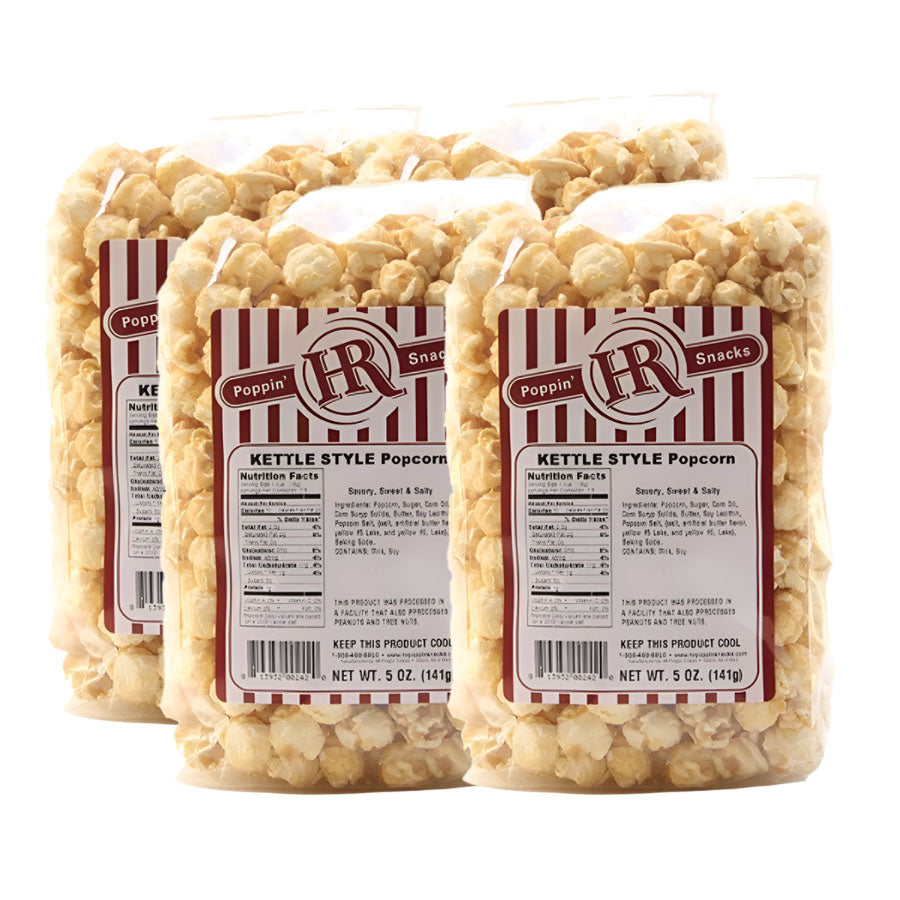 Four bags of kettle style popcorn with visible labels on a white background