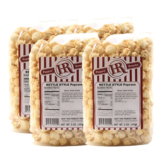 Four bags of kettle style popcorn with visible labels on a white background