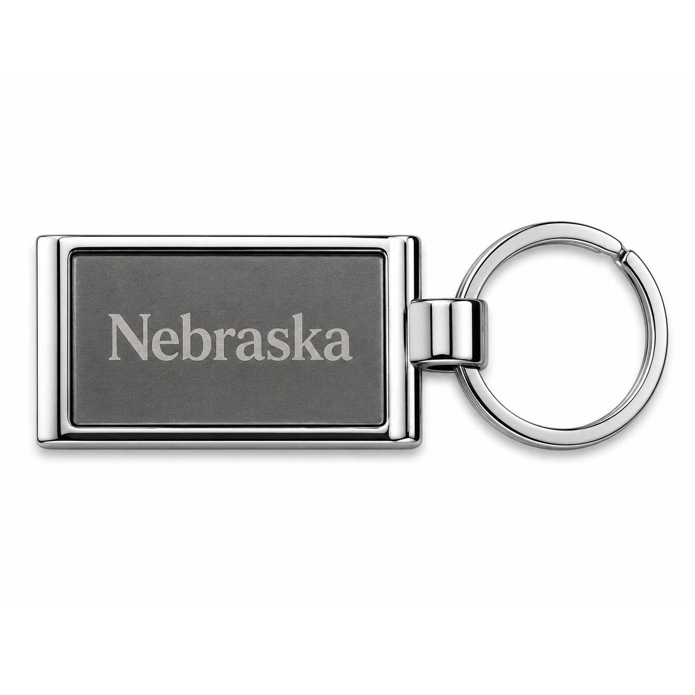 A rectangular metal keychain with a dark gray engraved face reading 'Nebraska' and a shiny silver-toned split ring, shown on a plain white background.