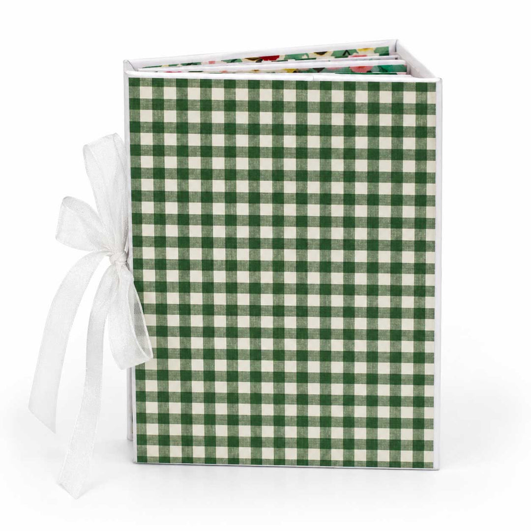 A square gift box with a green and white gingham patterned cover, tied with a white ribbon, shown on a clean white background.