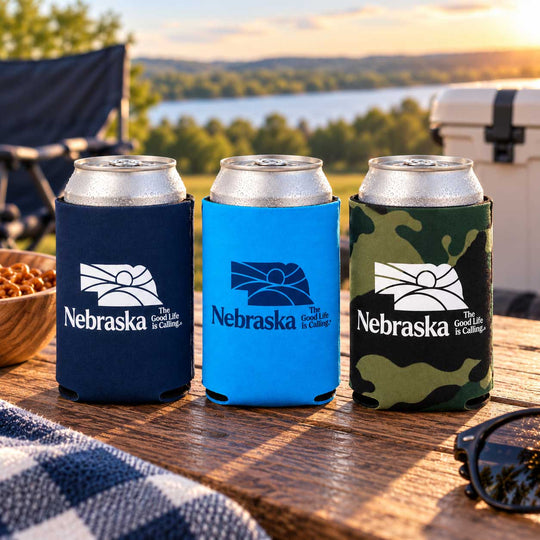 Three Nebraska Koozies on a picnic table