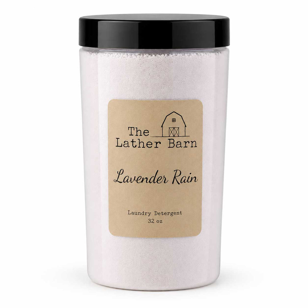 A 32 oz jar of 'Lavender Rain' laundry detergent by The Lather Barn, featuring a black lid and a beige kraft paper label, shown on a white background.