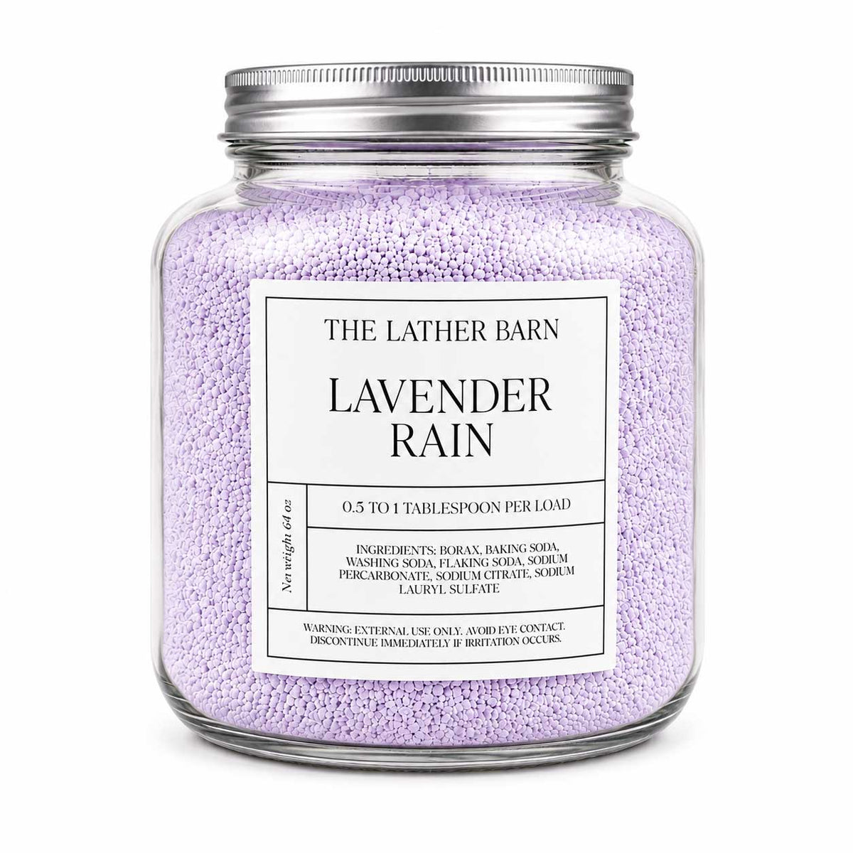 A clear glass jar candle filled with light lavender-colored granules, featuring a silver metal lid and a white label that reads 'THE LATHER BARN LAVENDER RAIN'.