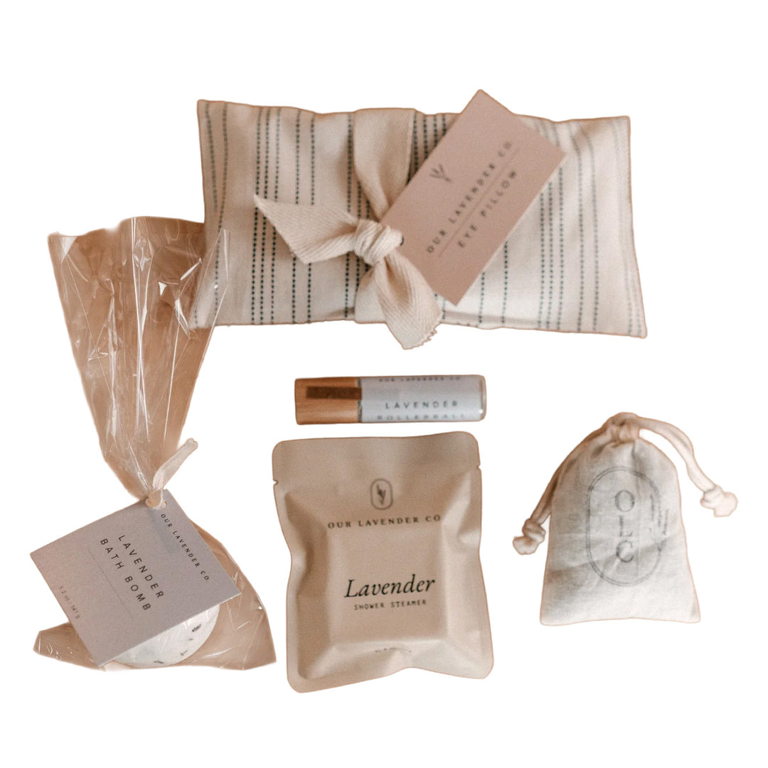 Collection of lavender-themed products including a soap bar, bath bomb, and shower steamer on a white background.