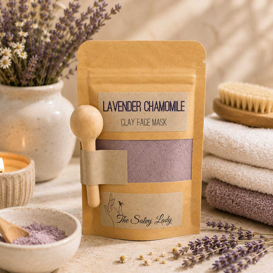 Lavender Chamomile Clay Face Mask packaging with wooden spoon and lavender flowers on a neutral background