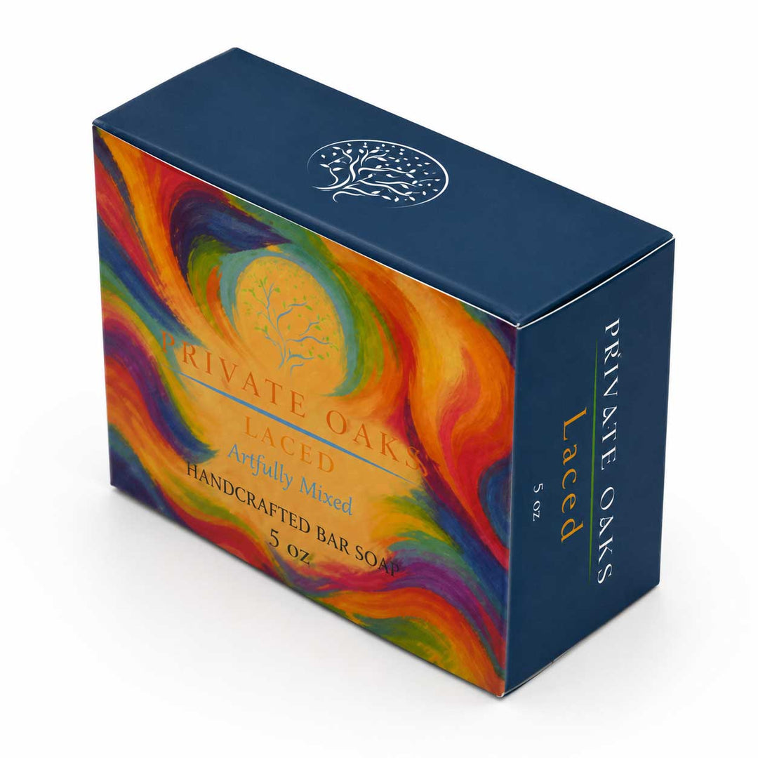A 5 oz box of Private Oaks Laced Handcrafted Bar Soap, featuring a dark blue box with a vibrant, multicolored abstract swirl design on the front and side.