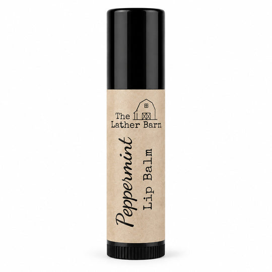 A single tube of Peppermint Lip Balm by The Lather Barn, featuring a natural kraft paper label and a black cap, set against a plain white background.