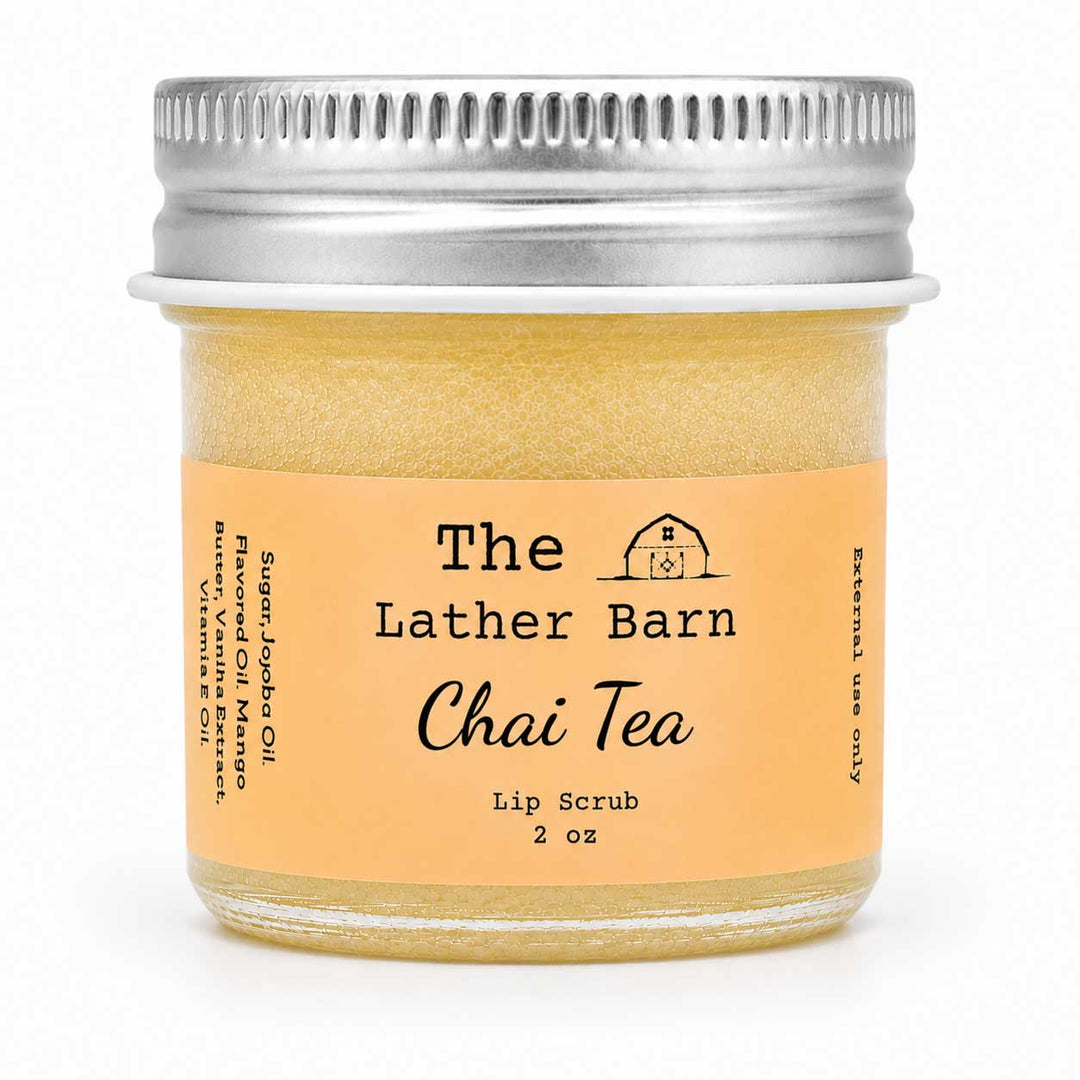 A 2 oz glass jar of 'The Lather Barn Chai Tea Lip Scrub' with a light orange label and a silver metal screw-on lid, shown on a white background.
